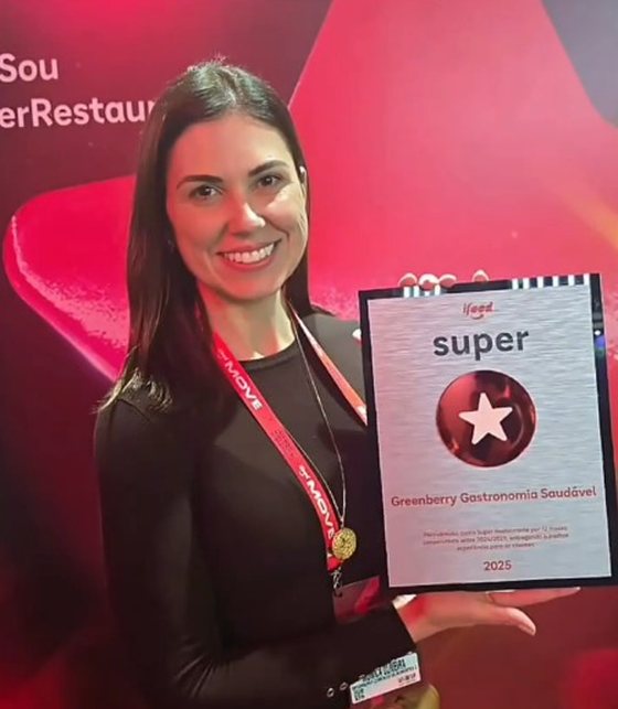 Mônica com a placa do prêmio Super Restaurante iFood